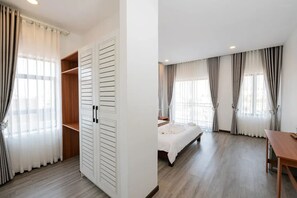 A bedroom with a bed, a wooden table, and a wardrobe. - Sreng Angkor Hotel (Krong Siem Reap)