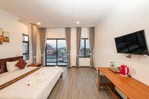 A hotel room with a bed, a desk, a TV, and a window with curtains. - Sreng Angkor Hotel (Krong Siem Reap)