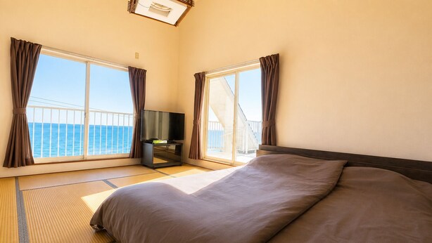 Ein Hotelzimmer mit Bett, Fernseher und Meerblick.
