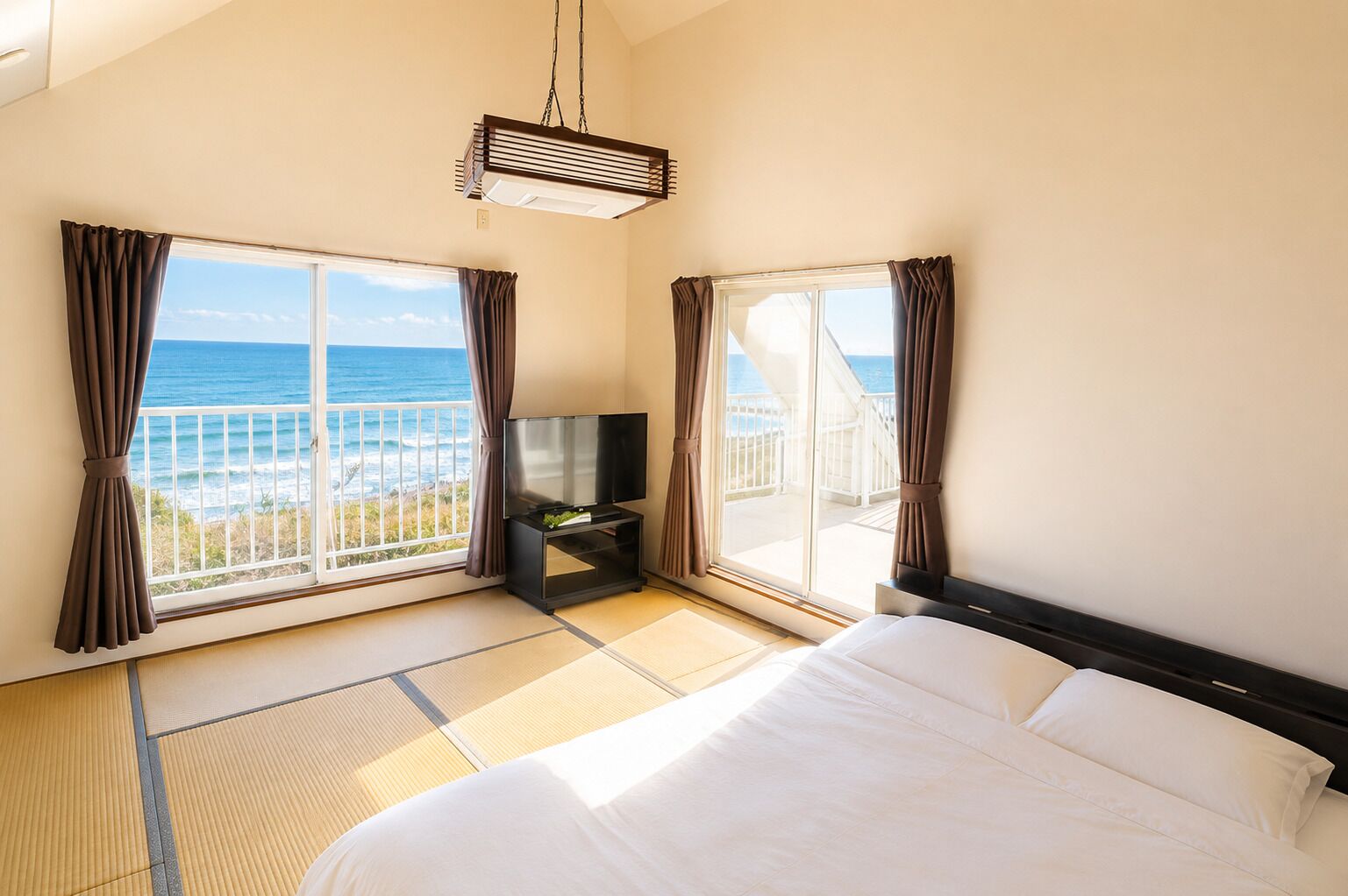 Une chambre d’hôtel avec un lit, une télévision et une vue sur l’océan.