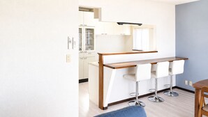 Eine moderne Küche mit Barbereich, weißen Schränken und einer Holzausziehtafel.
