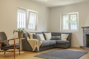 A living room with a sofa, a chair, a rug, and a fireplace. - Cascais Boutique Retreat by Clama Retreats (Cascais)