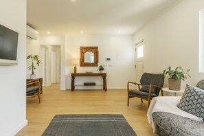 Een moderne woonkamer met een bank, fauteuils, een salontafel en een open haard.