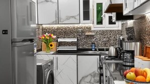 Una cucina moderna con lavatrice integrata, lavello e piano cottura.