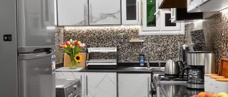 A modern kitchen with a built-in washing machine, a sink, and a stove.