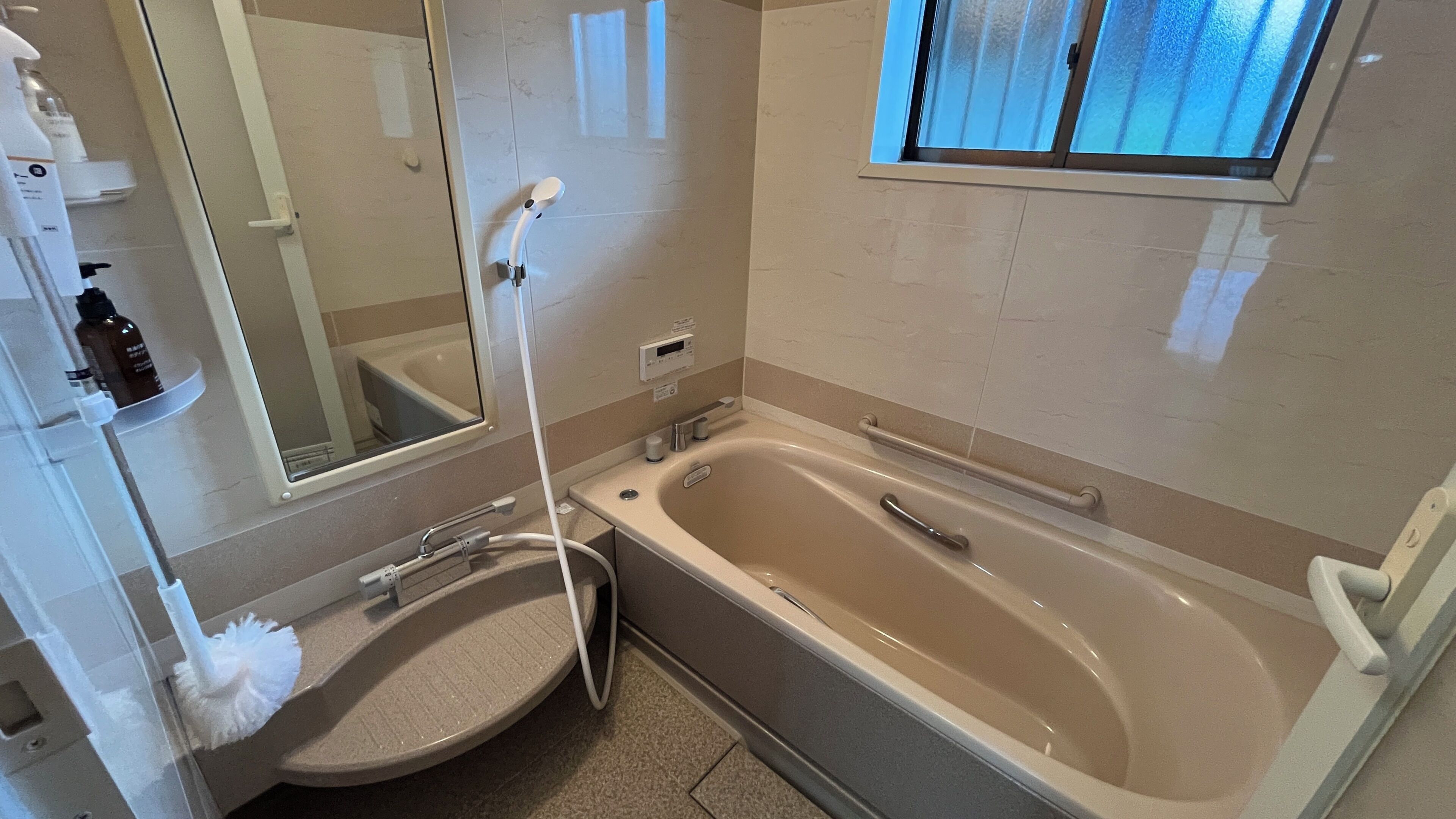 Une salle de bain avec une baignoire, un lavabo, un miroir et une fenêtre.