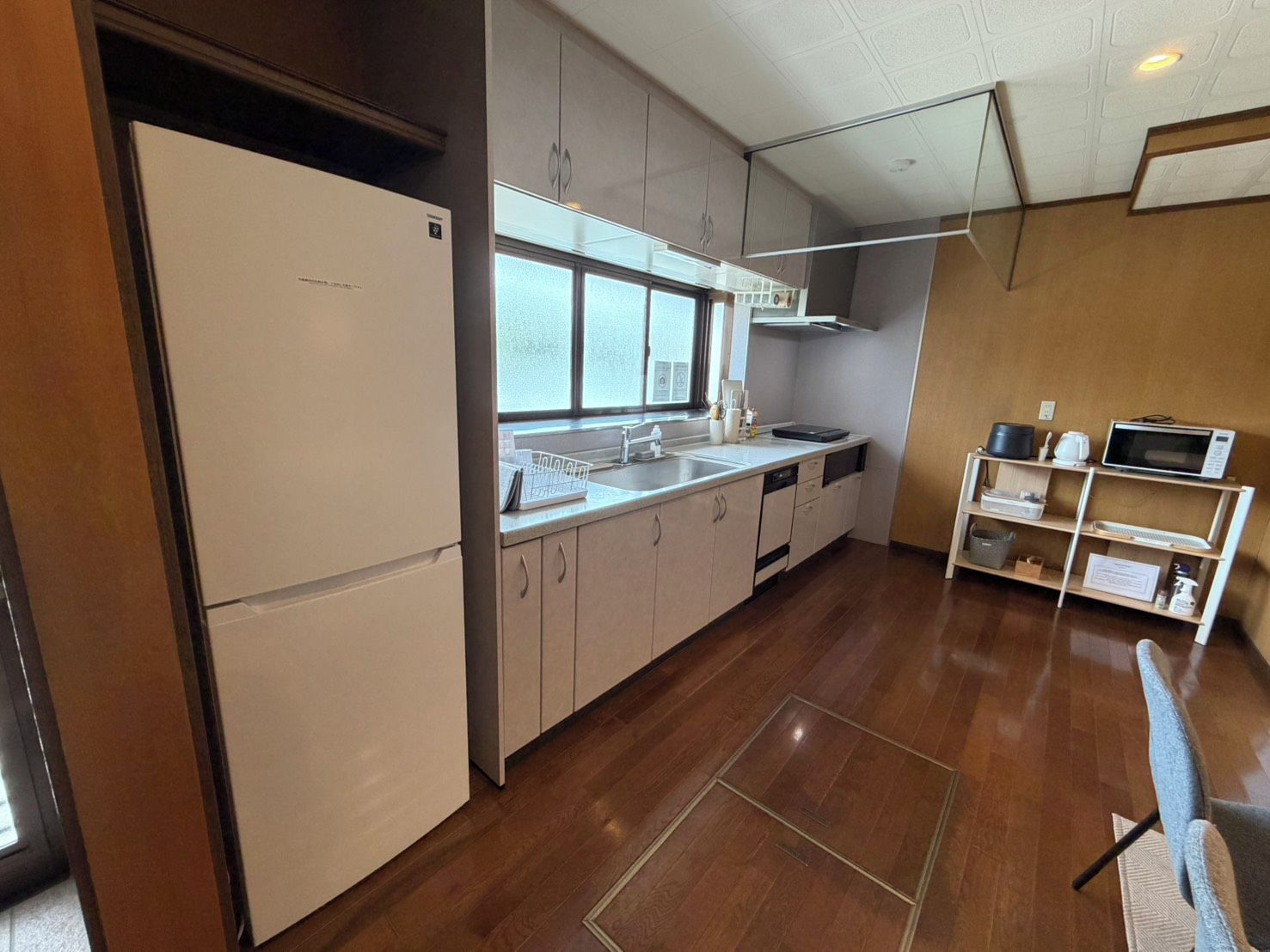 A modern kitchen with a refrigerator, sink, and microwave.