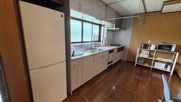 A modern kitchen with a refrigerator, sink, and microwave.