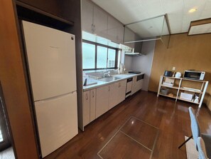 A modern kitchen with a refrigerator, sink, and microwave. - Natsumi, Nabari City, Mie Prefecture: Sophisticated Japanese-Style Home  Himiki An Vacation Rental: Up to 5 guests at the same rate; 20% off for 7 nights; 40% off for a full month (Nabari)