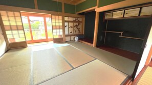 A tatami mat room with sliding doors, a traditional Japanese room divider, and a small table with a fan. - Natsumi, Nabari City, Mie Prefecture: Sophisticated Japanese-Style Home  Himiki An Vacation Rental: Up to 5 guests at the same rate; 20% off for 7 nights; 40% off for a full month (Nabari)