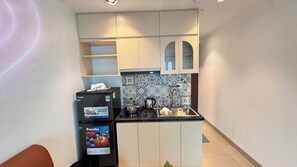 Cocina compacta con estufa, lavamanos y dos refrigeradores.