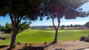 A golf course with trees, a clear sky, and distant mountains. - El Valle Golf Residence | Private Terraces & Pools (Murcia)