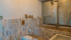 A bathroom with a bathtub, toilet, and shower. - Colombo Suites, the stunning Ligurian Riviera: a taste of nature and relaxation (Lavagna)