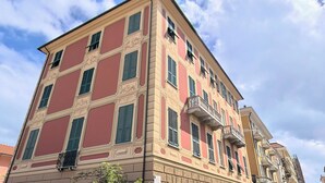 A multi-story building with a classic architectural style, featuring a balcony on the second floor. - Colombo Suites, the stunning Ligurian Riviera: a taste of nature and relaxation (Lavagna)