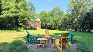 An outdoor seating area with Adirondack chairs and a fire pit. - Heart of Nova Scotia’s South Shore - Curated Luxury in a Landmark Home (Mahone Bay)