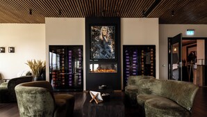 A lobby with a fireplace, seating area, and a wall with framed artwork. - Rosenlund Hamn (Sande)