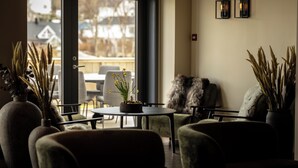 A cozy seating area with a table, chairs, and a vase of flowers. - Rosenlund Hamn (Sande)
