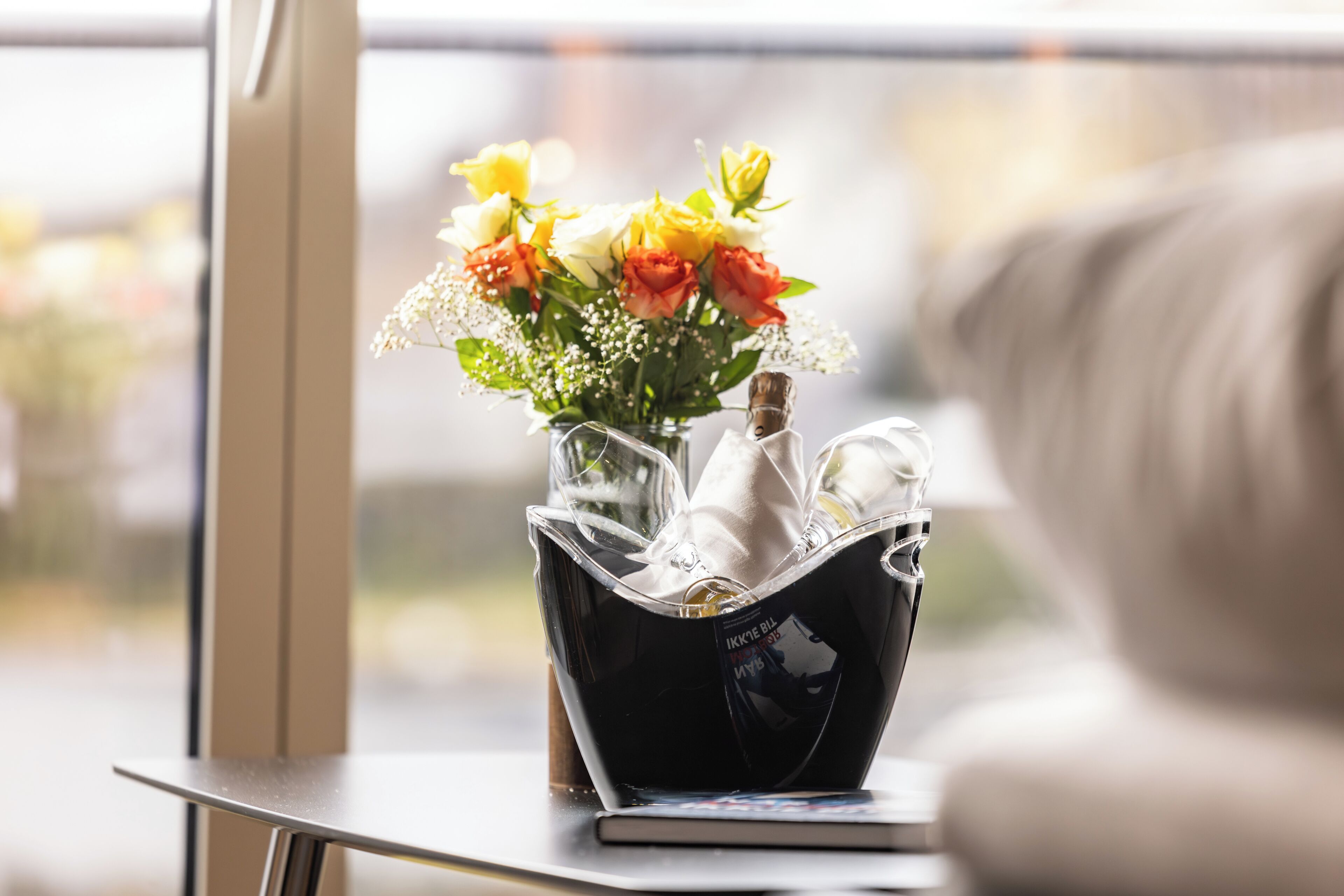 A vase with flowers on a table near a window.