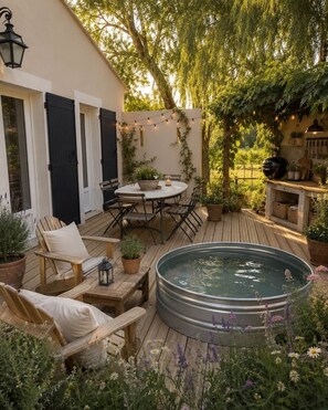Eine Holzterrasse mit Whirlpool, Sitzgelegenheiten im Freien und Lichterketten.