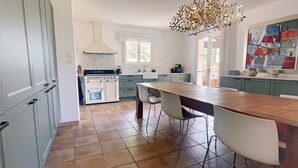 A modern kitchen with a central island, white cabinetry, and a decorative chandelier. - Holiday Home 'L’Isclèze' with Mountain View, Wi-Fi and Air Conditioning (Mollans-sur-Ouvèze)