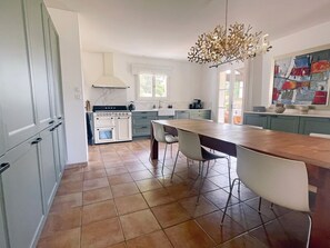 A modern kitchen with a central island, white cabinetry, and a decorative chandelier. - Holiday Home 'L’Isclèze' with Mountain View, Wi-Fi and Air Conditioning (Mollans-sur-Ouvèze)