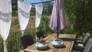 An outdoor patio with a wooden table, wicker chairs, and a purple umbrella. - Holiday Home 'L’Isclèze' with Mountain View, Wi-Fi and Air Conditioning (Mollans-sur-Ouvèze)