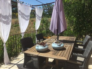 An outdoor patio with a wooden table, wicker chairs, and a purple umbrella. - Holiday Home 'L’Isclèze' with Mountain View, Wi-Fi and Air Conditioning (Mollans-sur-Ouvèze)