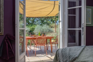 An open door leading to an outdoor patio with a table, chairs, and a yellow canopy. - Holiday Home 'L’Isclèze' with Mountain View, Wi-Fi and Air Conditioning (Mollans-sur-Ouvèze)