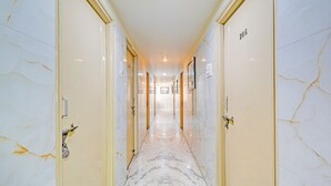 Een hal met marmeren vloer, met deuren aan beide zijden, genummerd 206 en 207, die naar kamers leiden.