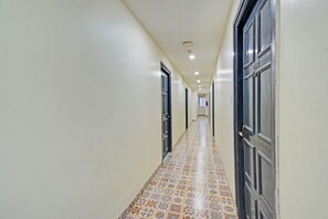 Un pasillo con baldosas de diseño, puertas a ambos lados e iluminación empotrada.