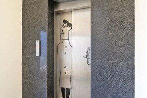 An elevator with a metallic interior and a hand-drawn figure of a person. - FabHotel AM Castle - Nr ESI Hospital Metro Station (Hyderabad)
