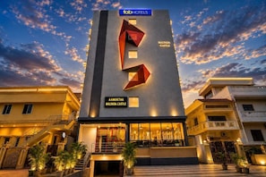Un hotel con fachada moderna, un logotipo geométrico llamativo y el nombre 'Malyada Castle' a la vista.