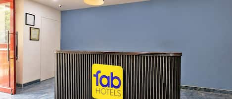 A reception desk with a 'fab hotels' sign, a ceiling light, and a patterned floor.