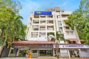 A multi-story hotel building with a sign for 'Hotel Imperial Palace - 1' and another sign for 'CILL PURE VEG.' - FabHotel Imperial Executive (Mumbai)