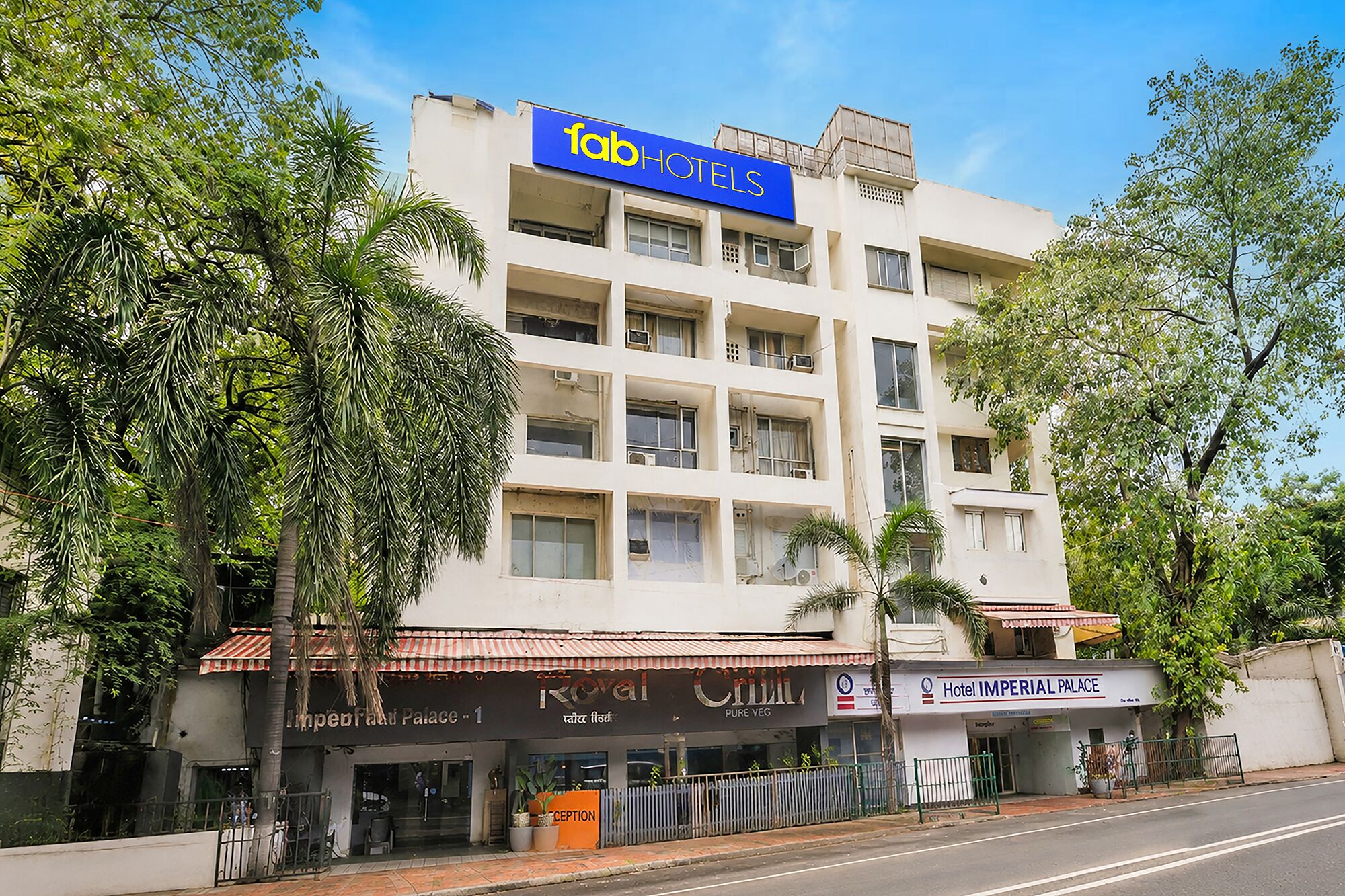 A multi-story building with a sign for 'fab HOTELS' and a restaurant named 'Royal Chilli' on the ground floor.