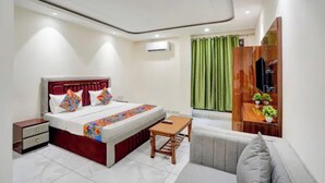 Een moderne hotelkamer met een bed, nachtkastje en een bank.