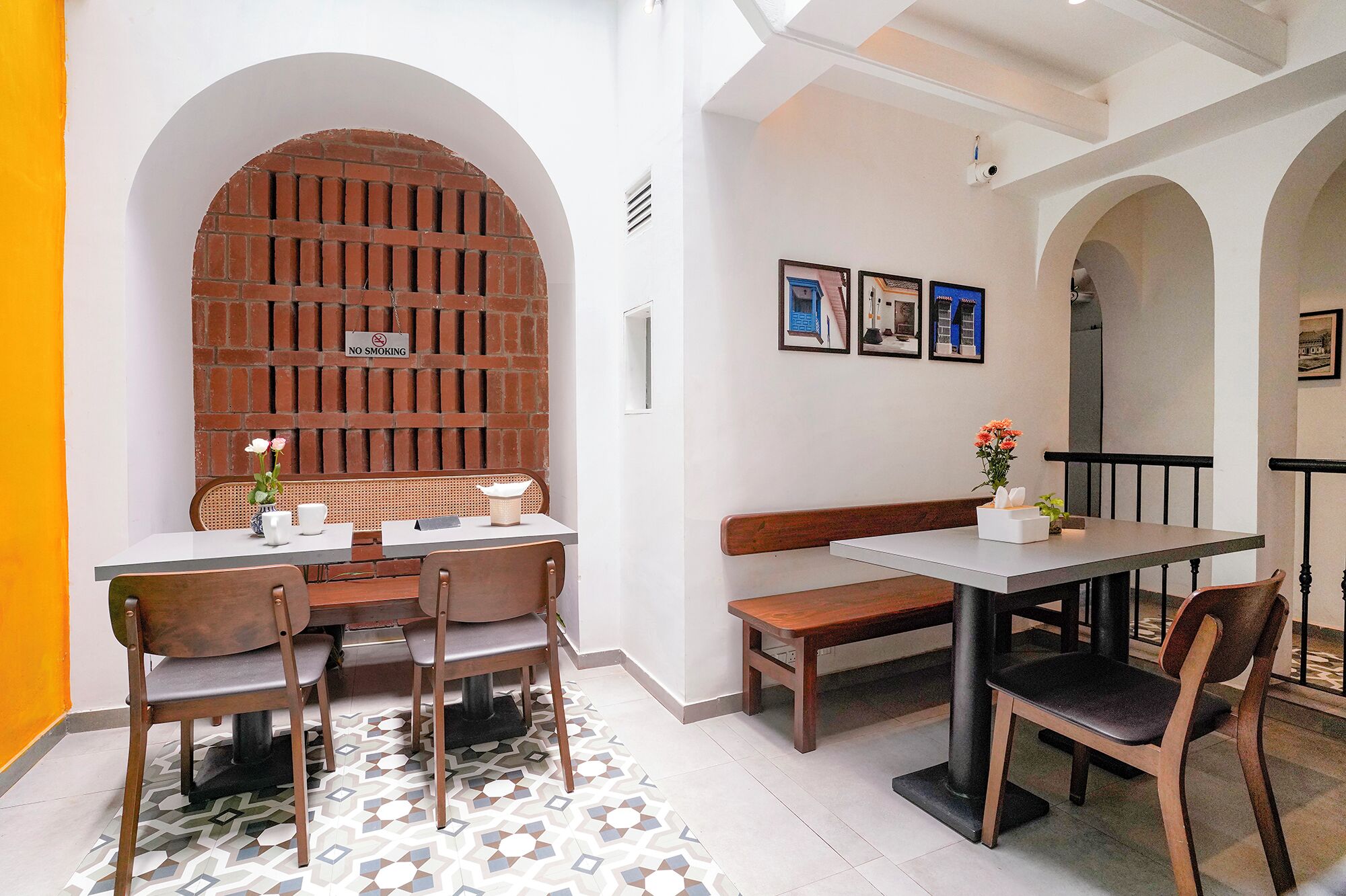 A dining area with a brick wall, a white table, and chairs.