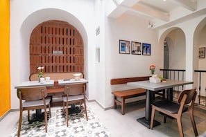 Un comedor con pared de ladrillo, una mesa blanca y sillas.