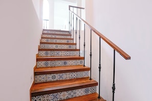 Una escalera con escalones de madera y barandillas de metal negro.