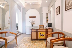 A hotel reception area with a reception desk, chairs, a decorative vase, and a sign for Fab Hotels. - FabHotel Casa Bharat (Panaji)