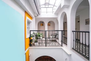 A multi-level interior with a balcony, arched ceilings, and a tiled floor.