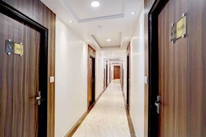 Corredor de hotel com portas numeradas 101 e 108, dando acesso aos quartos.