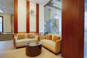 Una sala de estar moderna con dos sofás, una mesa de centro de vidrio y un mueble de madera.