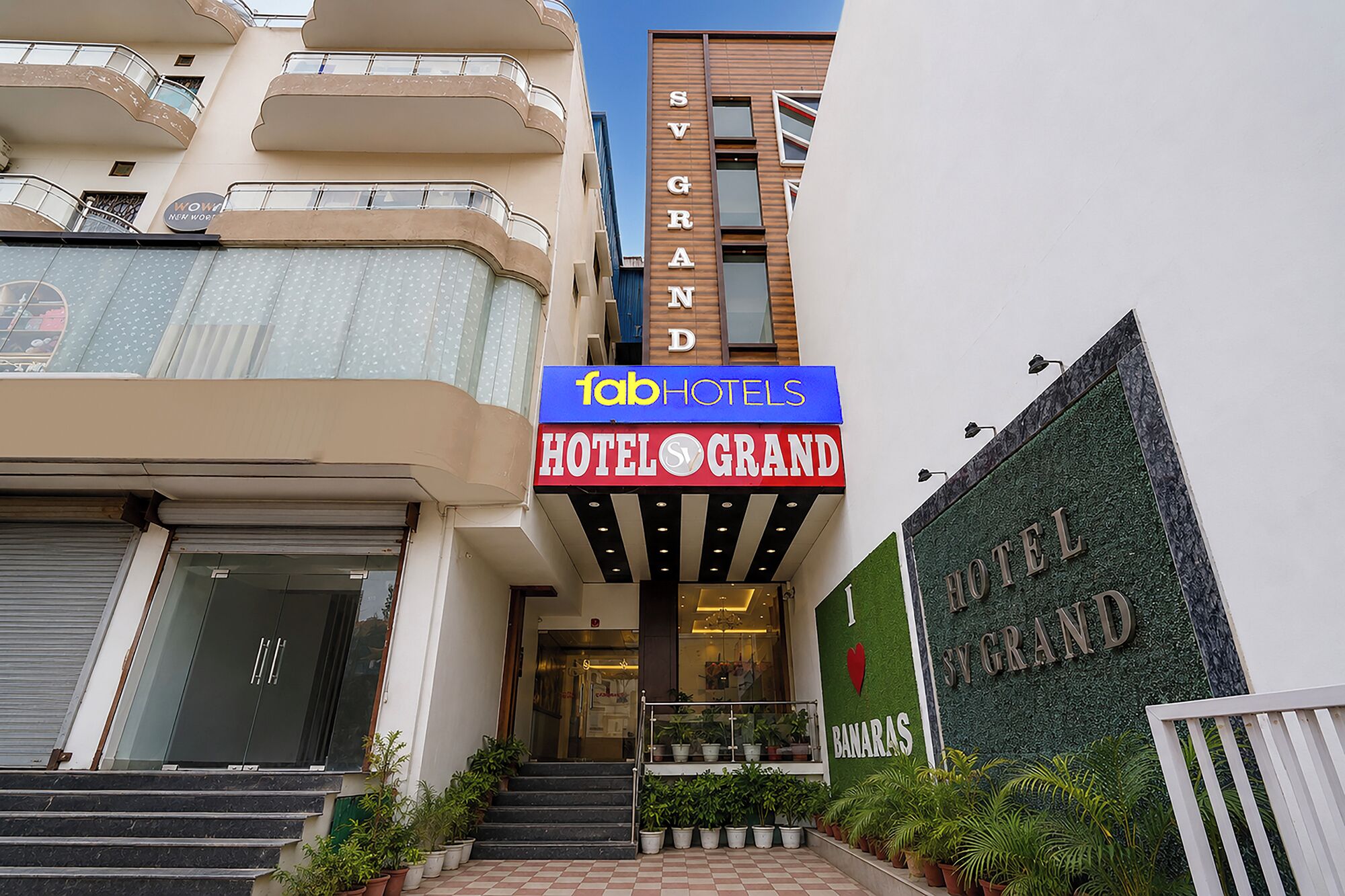 L’entrée d’un hôtel, avec une enseigne indiquant « Hôtel Grand » et « Tab Hotels » au-dessus.