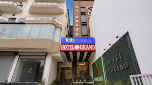 En hotellentrédörr med en skylt ovanför som visar texten ”Hotel Grand” och ”Tab Hotels”.