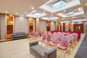 A conference room with rows of chairs, a sofa, and a chandelier. - FabHotel SV Grand I - 1 KM From Kashi Vishwanath Temple (Varanasi)