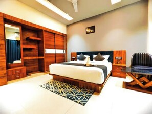 Una habitación de hotel con una cama grande, un escritorio, un armario y un espejo.