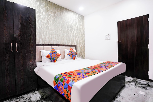 A bedroom with a bed, a wardrobe, and a door. - Fabhotel Yash Residency Ii (Ambernath)