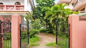 A gated entrance to a property with a pathway leading to a lush garden area. - Fabhotel Bounty Yatra (Arpora)