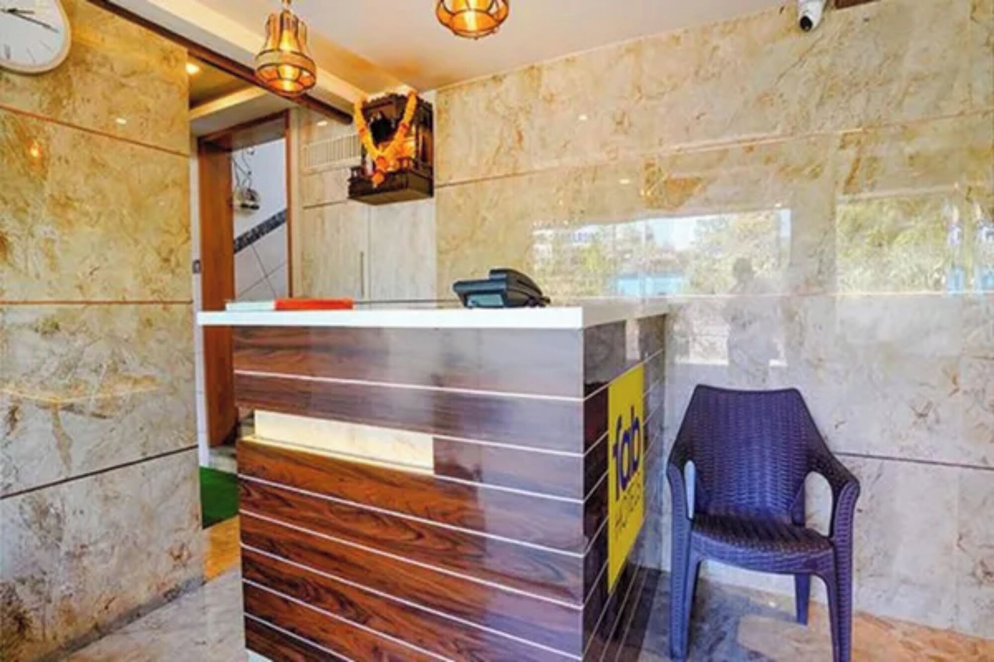 Un mostrador de recepción con un teléfono, una silla y una guirnalda decorativa.